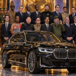 Satirisches Gruppenporträt mit schwarzem BMW